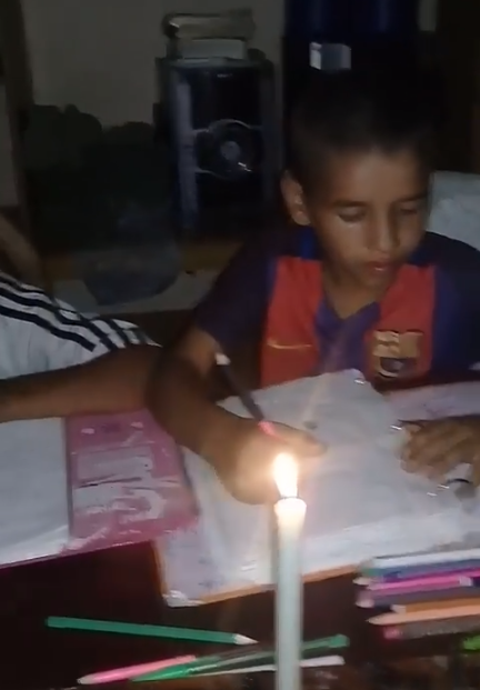 niños estudian con velas